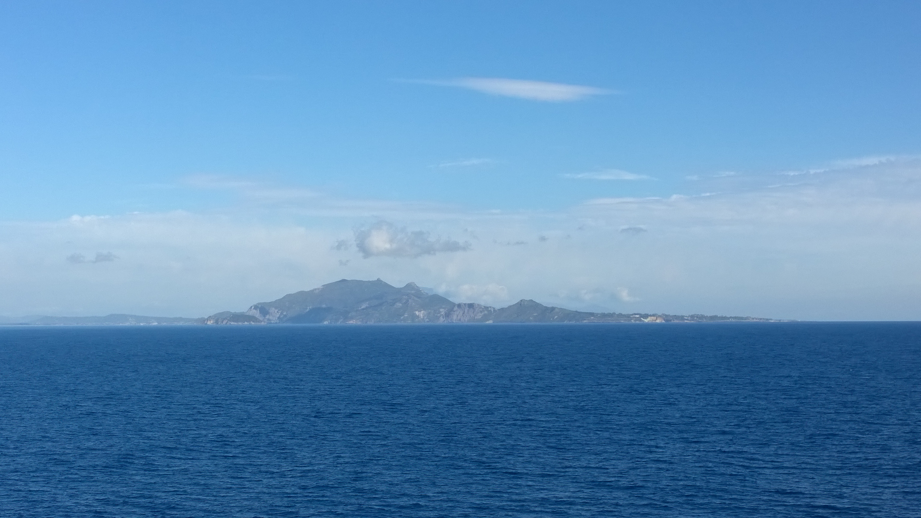 Distant Island With Calm Blue Sea, nature fine art print by UNFRAMED Archive, 24 x 16 in